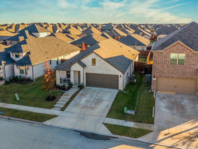 view of front of house with a front lawn, a garage, and cooling unit