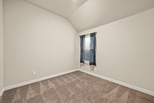 carpeted spare room featuring lofted ceiling