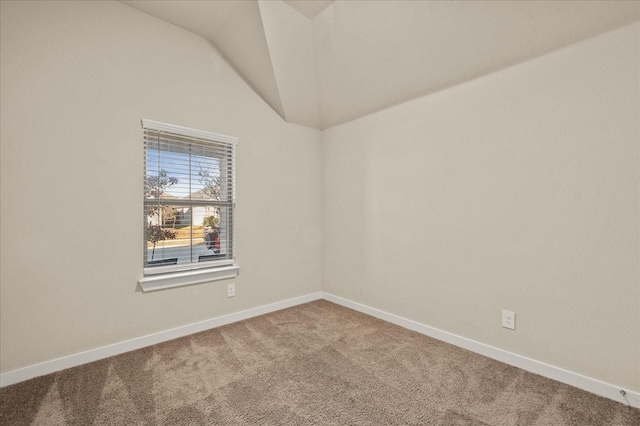 spare room featuring carpet floors and lofted ceiling