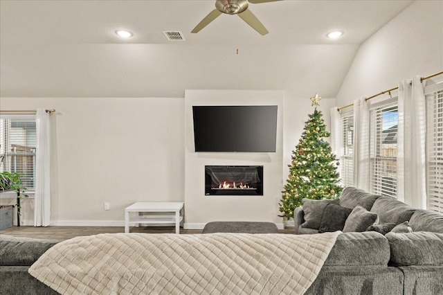 bedroom with ceiling fan, wood-type flooring, lofted ceiling, and multiple windows