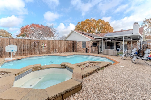 view of swimming pool with an in ground hot tub