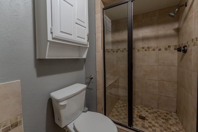 bathroom featuring toilet and a shower with door