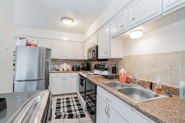 kitchen with white cabinets, stainless steel refrigerator, and sink