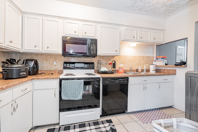 kitchen with sink, light tile patterned floors, decorative backsplash, white cabinets, and black appliances