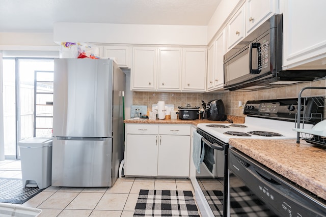 kitchen with white electric stove, decorative backsplash, light tile patterned floors, white cabinetry, and stainless steel refrigerator