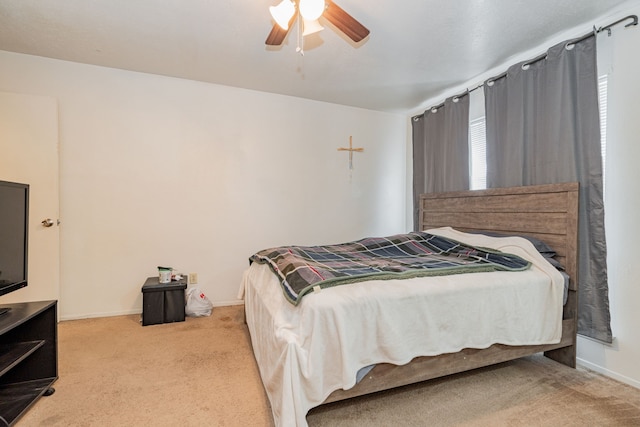 bedroom with multiple windows, ceiling fan, and light colored carpet