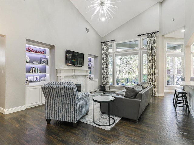 living room with a fireplace, dark hardwood / wood-style floors, high vaulted ceiling, and a notable chandelier