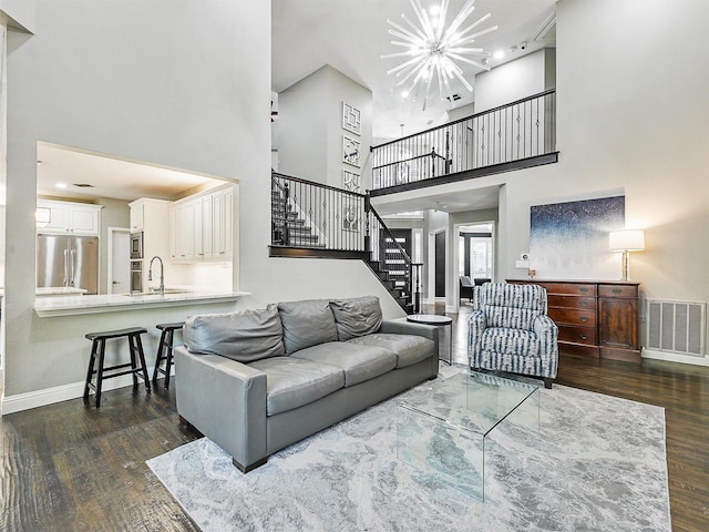 living room with a high ceiling, dark wood-type flooring, and sink