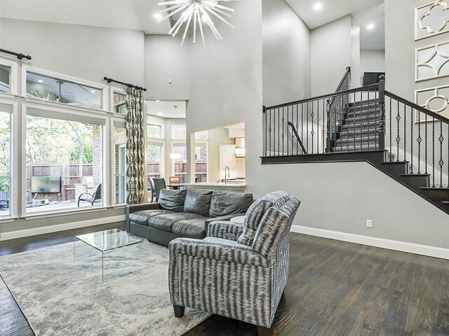 living room featuring dark hardwood / wood-style flooring, sink, high vaulted ceiling, and a chandelier