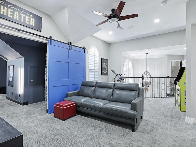 living room with a barn door, light colored carpet, and ceiling fan with notable chandelier