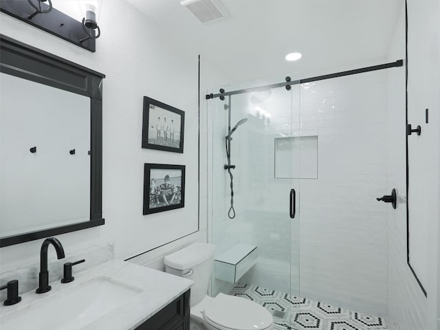 bathroom with vanity, toilet, and a shower with shower door