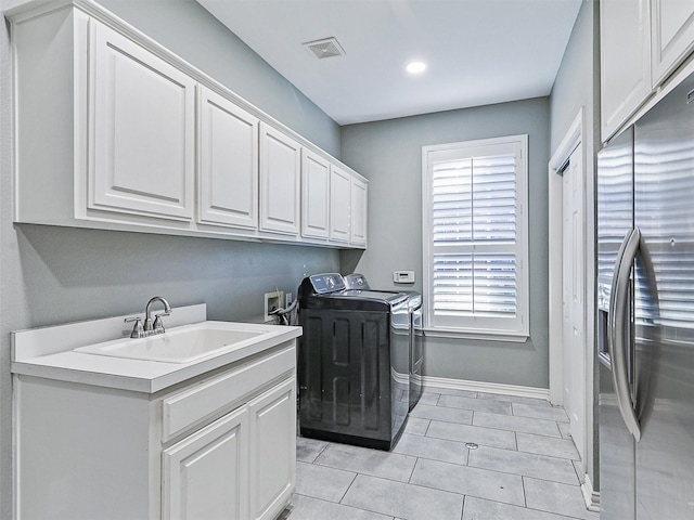 washroom with cabinets, separate washer and dryer, sink, and light tile patterned floors