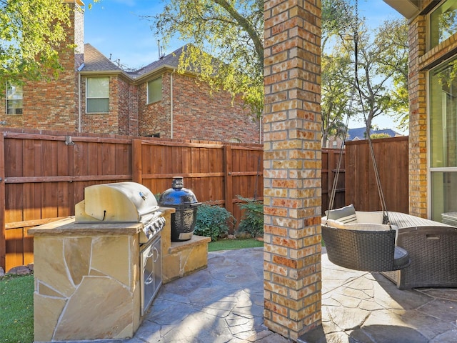 view of patio / terrace featuring exterior kitchen and a grill