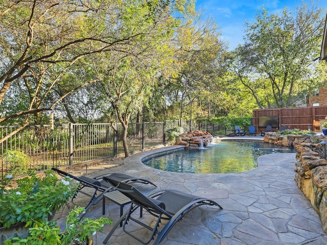 view of swimming pool with pool water feature and a patio