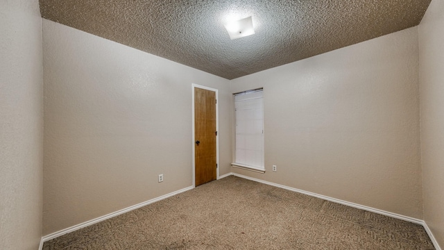 spare room featuring carpet flooring and a textured ceiling