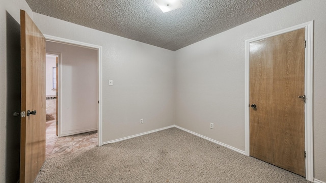 carpeted spare room with a textured ceiling