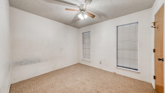 spare room with light carpet, ceiling fan, and a textured ceiling