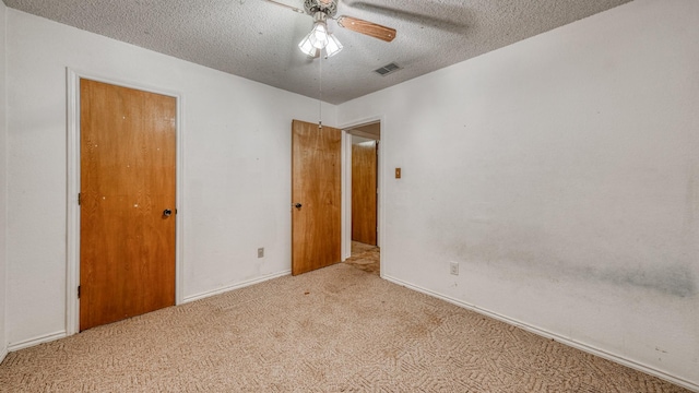 empty room featuring light carpet, a textured ceiling, and ceiling fan