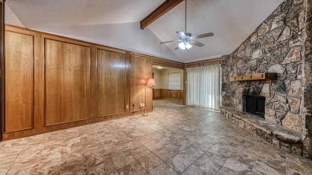 unfurnished living room featuring beam ceiling, ceiling fan, a stone fireplace, high vaulted ceiling, and a textured ceiling