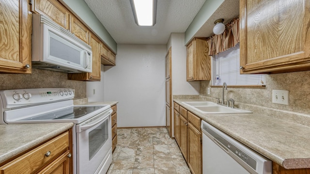 kitchen featuring a textured ceiling, white appliances, and sink