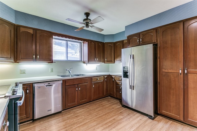 kitchen with stainless steel appliances, ceiling fan, light hardwood / wood-style floors, and sink