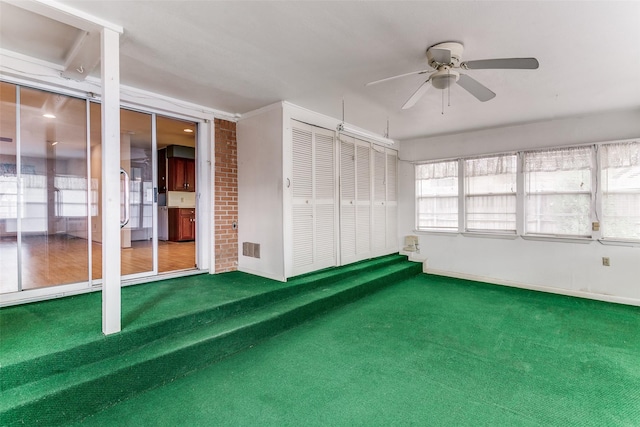 unfurnished sunroom with a wealth of natural light and ceiling fan