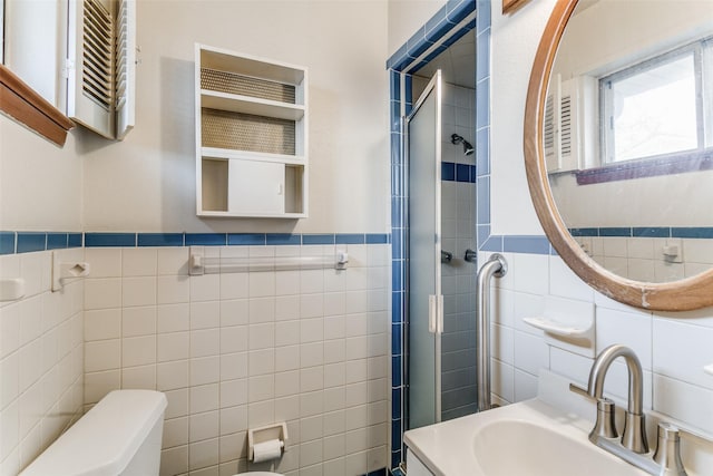 bathroom featuring sink, toilet, a shower with door, and tile walls