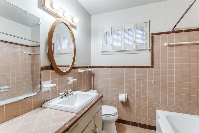 full bathroom featuring vanity, tiled shower / bath combo, tile walls, and toilet