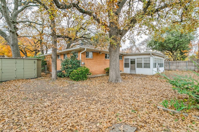 rear view of property featuring a sunroom