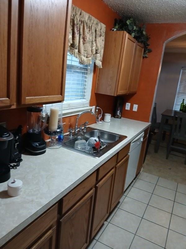 kitchen featuring dishwasher, light tile patterned floors, and sink