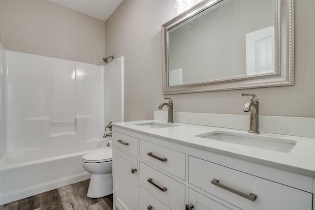 full bathroom featuring hardwood / wood-style floors, vanity, toilet, and shower / washtub combination