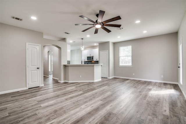 unfurnished living room featuring light hardwood / wood-style floors and ceiling fan