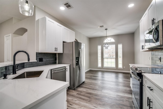 kitchen with decorative backsplash, white cabinetry, sink, and appliances with stainless steel finishes