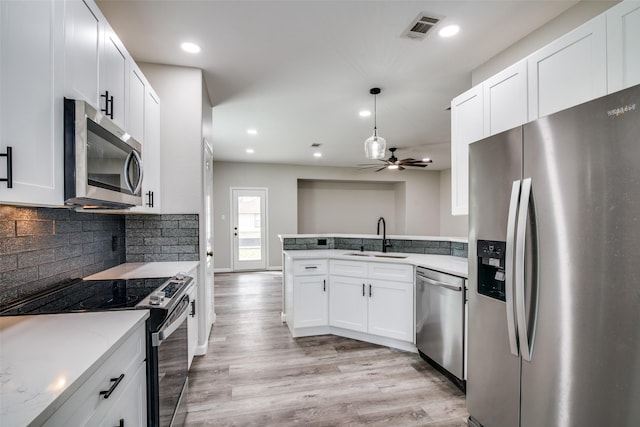 kitchen with white cabinets, sink, ceiling fan, appliances with stainless steel finishes, and light hardwood / wood-style floors