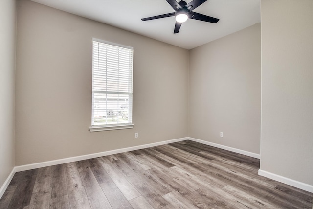 spare room featuring ceiling fan, a healthy amount of sunlight, and hardwood / wood-style flooring