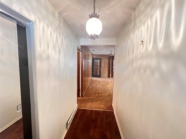 corridor featuring dark hardwood / wood-style flooring and a textured ceiling