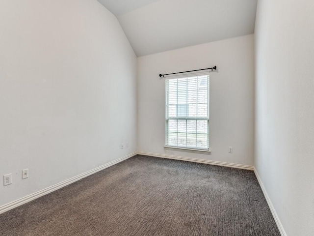 carpeted spare room with lofted ceiling