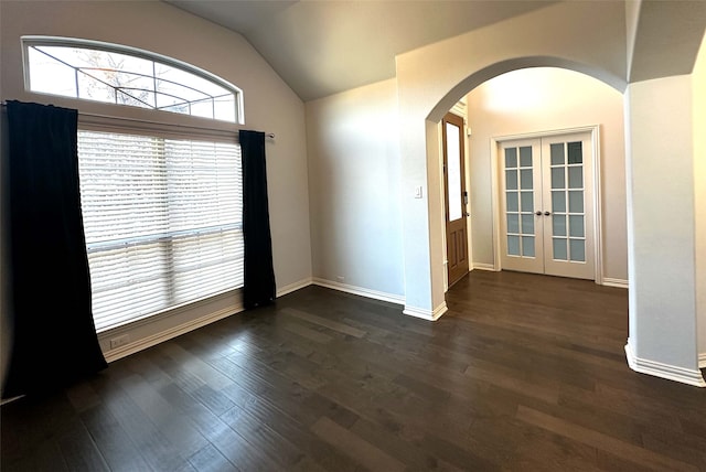 spare room featuring dark hardwood / wood-style flooring, french doors, and vaulted ceiling