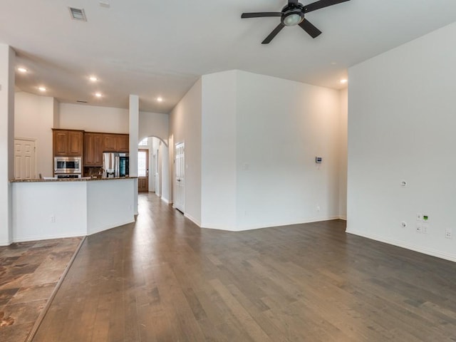 unfurnished living room featuring dark hardwood / wood-style floors and ceiling fan