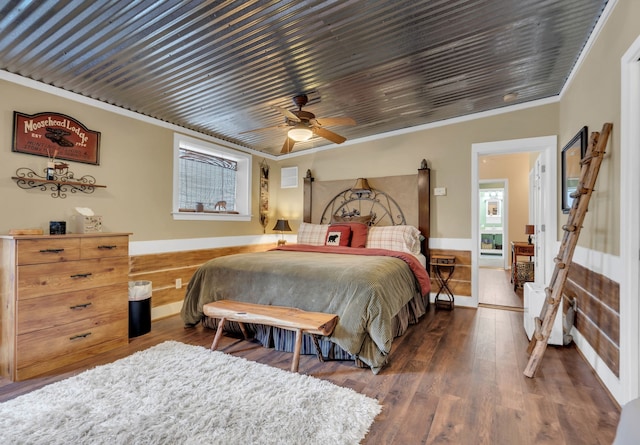 bedroom featuring crown molding, dark wood-type flooring, and ceiling fan