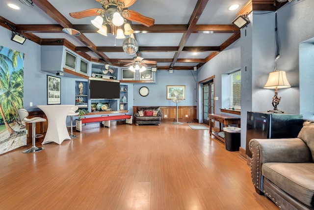 living room featuring ceiling fan, coffered ceiling, light hardwood / wood-style floors, and beam ceiling