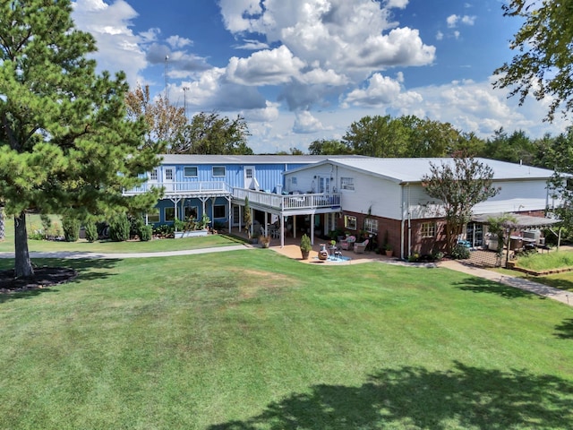 rear view of house featuring a patio, a yard, and a deck