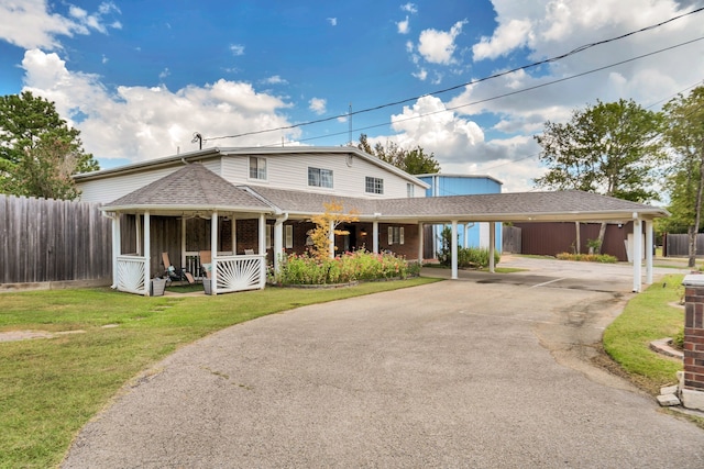 farmhouse featuring a carport and a front yard