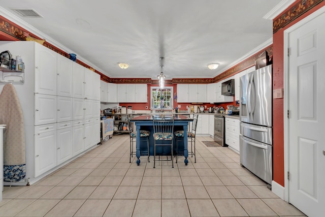 kitchen featuring a breakfast bar, a kitchen island, pendant lighting, stainless steel appliances, and white cabinets