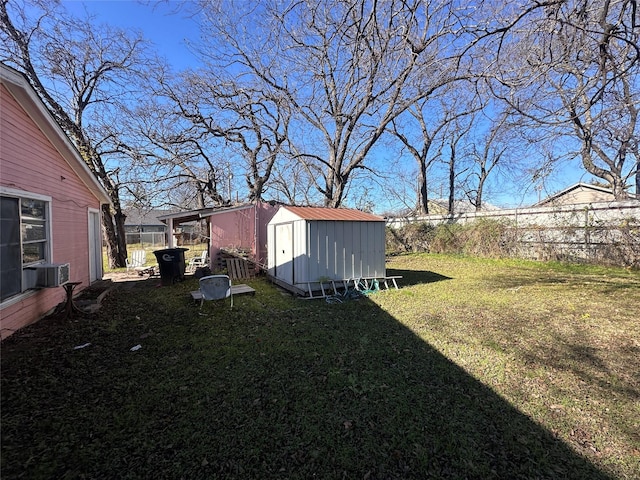 view of yard with central AC unit and a shed