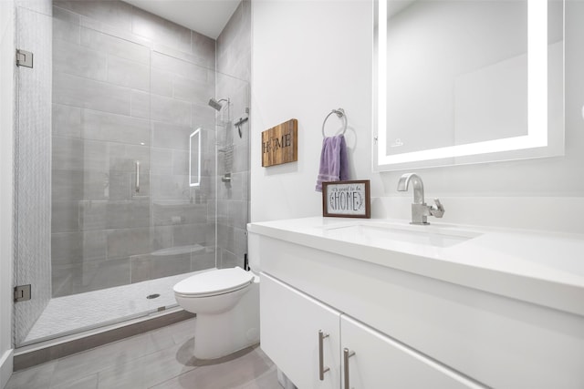 bathroom featuring vanity, toilet, and a shower with shower door