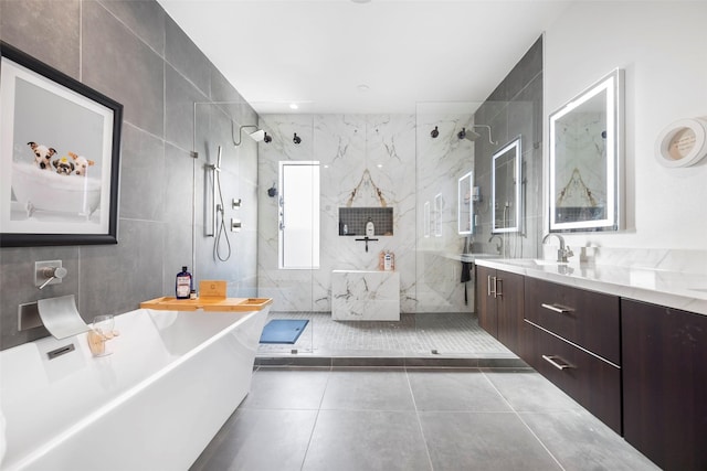 bathroom with tile patterned flooring, vanity, tile walls, and plus walk in shower