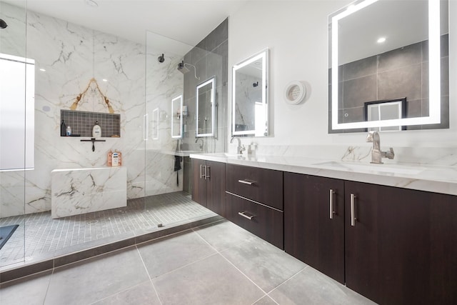 bathroom with tile patterned flooring, vanity, and a tile shower