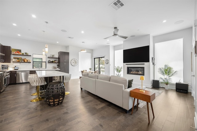 living room featuring dark hardwood / wood-style flooring, ceiling fan, and sink