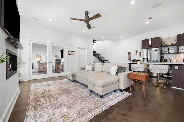 living room featuring dark hardwood / wood-style flooring, ceiling fan, and french doors